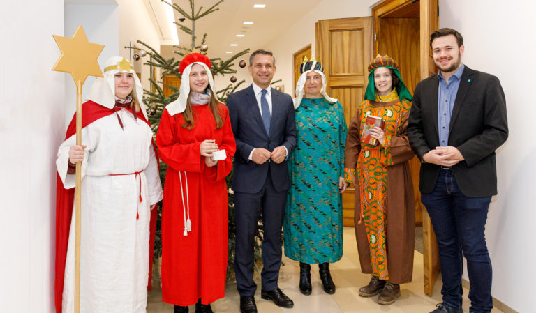 Sternsinger aus der Linzer Pfarre Christkönig und der Vorsitzende der Katholischen Jungschar der Diözese Linz Samuel Haijes überbringen Landesrat Hattmannsdorfer den Segen für das neue Jahr